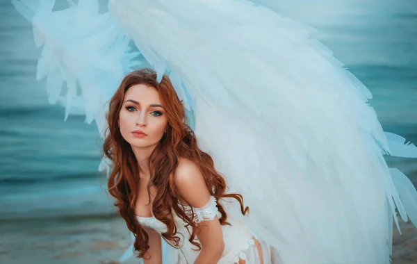 Portrait of an attractive adult angel girl, innocent face blue eyes. Beautiful fashion model young fantasy Woman with white bird wings feathers. Greek goddess costume. Background - nature, water river — Stock Photo, Image