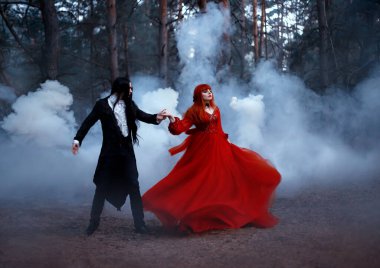 Bulanık siluet, sis içinde dans eden Gotik çiftin hareketi. Siyah paltolu vampir prens kadınları baştan çıkarıyor. kırmızı ortaçağ elbisesi. Uzun saçlı kız prenses. Rüzgarda uçuşan kumaş etek
