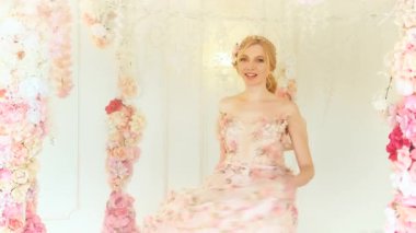 Portre sarışın mutlu kadın gelin dans ediyor, gülümseyen neşeli yüz. Bayan bahar perisi, pembe, lüks balo elbisesi giyen beyaz klasik odayı sallıyor. Şık sarı saç, klasik saç modeli prenses 4k.