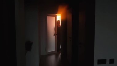 Karanlık gölgeli genç kadın kapıyı ilahi güneş ışınlarıyla açar gün batımını seyreder, yetişkin kız odadan çıkar ve siyah uzun koridor evine gider. Gotik, gizemli, gizemli kadın. Uzun akşam seksi elbisesi.