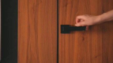 Tarz sahibi, siyah kapı kolunu sıkıca kavrayan, iç açılış sisteminin içindeki son moda ahşap kapıyı iten, tanınmamış biri. Kadın sınıfa giriyor. Amerikan ceviz kaplaması..