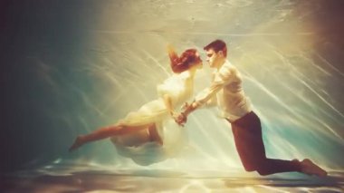 Fantezi romantik çift aşık olur erkek kral ve kadın su altında kucaklaşır. Islak beyaz elbise. Kızıl saçlı seksi kız Yunan tanrıçası nehir perisi deniz kızı yüzücüleri boğulan adamı baştan çıkarır. Yaratıcı çekim