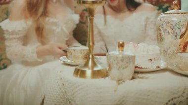 İki bulanık siluet Mutlu kadınlar sehpada koltukta oturan asil kadınlar çay partisi yaparlar. Kız istirahati, kadın kraliçe baş nedimeler okuyor. Kraliyet odası balosu elbisesi beyaz eski moda elbise eski tarz sanat