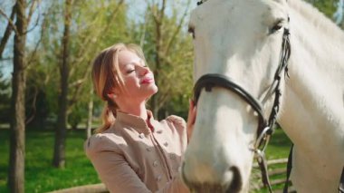 Güzel, güzel, gülümseyen yüz, kırmızı dudaklar, beyaz elli, at kürküne dokunan mutlu kadın, sanat portresi, at evcil hayvanı. Mutlu seksi kız eski moda kıyafetler sihirli güneş ışığı ağacı 4k