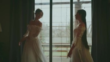 Karanlık siluet iki mutlu kadın klasik karanlık oda eğlencesi neşe içinde dans ediyor. Peri masalı yetişkin kızlar güzel asil kadın. Kraliyet evi beyaz eski moda balo elbisesi Victoria tarzı eski tarz parti 4k