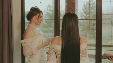 Pencereye bakan iki kadın. Soylu bayan prenses kraliyet kraliçesi klasik oda içinde. Gece uzun balo elbisesi beyaz, eski tarz elbise partisi. Dostlar, baş nedimeler, arkaya bakın..