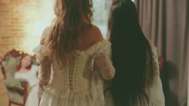 Kadın kraliçe ve arkadaş baş nedimeler iletişim kurar. Asil bayan, referans kız prensesi kanepede oturup çay partisi odasında eğlendiriyor. Beyaz balo elbisesi eski tarz sanat. Arka arkaplan.