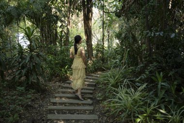 Ormanda yürüyen genç bir kadın.