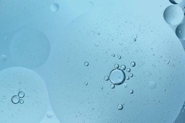 Su üzerinde yüzen yağ damlası veya kozmetik sıvı serumu mavi kabarcıklar arka plan