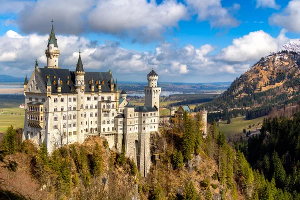 Вид на всемирно известный замок Нойштайн, дворец Возрождения XIX века, построенный для короля Феликса II, с живописным горным ландшафтом недалеко от Феттеля, юго-восточная Бавария, Германия — стоковое фото