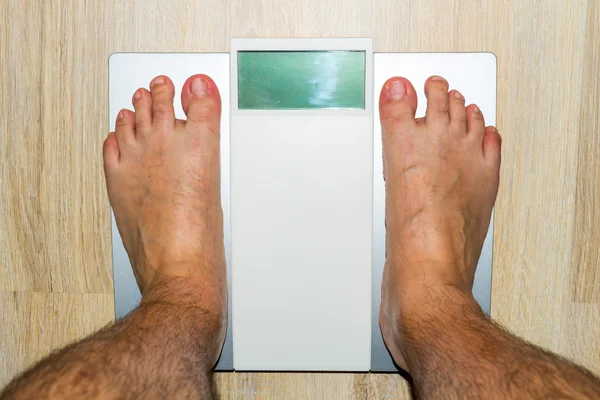 Człowiek stojący na wagi waga — Zdjęcie stockowe