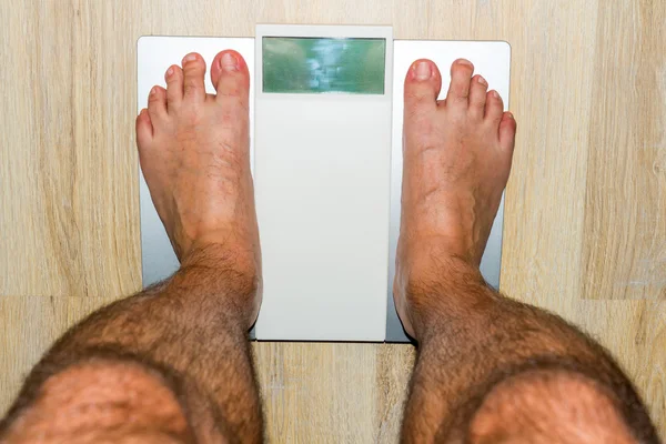Człowiek stojący na wagi waga — Zdjęcie stockowe