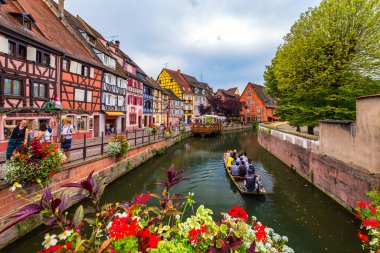Colmar, Fransa - 27 Temmuz 2018: Colmar, Alsace, Fransa. Renkli binalar, kanallar ve çiçekler. Colmar, Fransa. Petite Venedik, su kanalı ve geleneksel yarı ahşap evler.