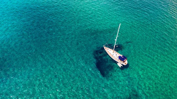 熱帯の島の前で透明なターコイズブルーの水の中でヨットの停泊 代替ライフスタイル ボートに住んでいます ターコイズブルーの水の上のアンカーでヨットの空中ビューは 豪華さ 富を示しています — ストック写真