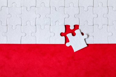 Beyaz yapboz. Renkli arka planda beyaz yapboz parçaları. Renk arkaplanındaki tamamlanmamış beyaz yapboz parçaları. 