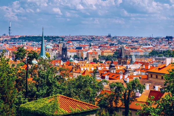 Prag 'ın kırmızı çatıları ve Prag' ın tarihi eski kasabasının düzinelerce kulesi. Güneşli bir günde Prag şehri manzarası. Arka planda kırmızı çatılar, kuleler ve Charles Köprüsü ve Vltava Nehri. Prag, Çek Cumhuriyeti.