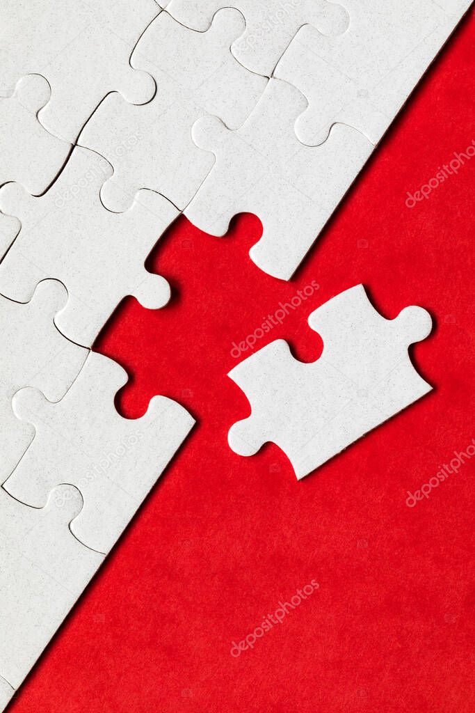 White jigsaw puzzle pieces. Fill in pieces of the jigsaw puzzle. Complete the jigsaw puzzle with the missing pieces. Fragment of a folded white jigsaw puzzle.