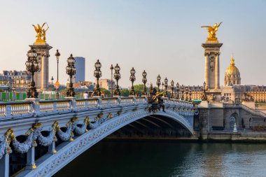 Pont Alexandre III köprüsü, güneşli bir yaz sabahı Seine nehrinin üzerinde. Art Nouveau lambaları ve heykellerle süslenmiş bir köprü. Paris, Fransa 'daki Seine Nehri' nin karşısındaki Alexander III Köprüsü..