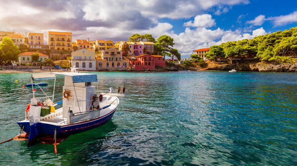 Деревня Ассос в Кефалонии, Греция. Бирюзовый залив в Средиземном море с красивыми красочными домами в деревне Ассос в Кефалонии, Греция, Ионический остров, Кефалония, деревня Ассос.