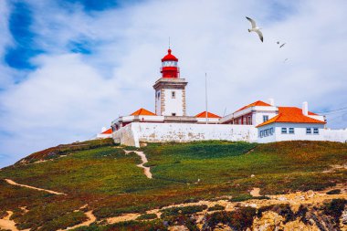 Cabo da Roca 'daki deniz feneri. Portekiz 'in güzel bir yaz gününde Sintra' da Atlantik Okyanusu kıyısındaki kayalıklar ve kayalar. Cabo da Roca, Portekiz. Atlantik Okyanusu üzerindeki deniz feneri ve kayalıklar.