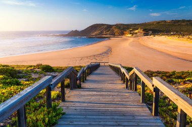 Praia da Amoreira sahiline tahta yol, Aljezur Bölgesi, Algarve Portekiz. Algarve Portekiz 'deki Amoreira plajından Panorama. Aljezur nehrinin sahil ve nehir kıyısı, Praia da Amoreira.