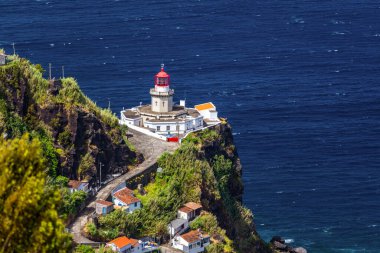 Dramatic view down to lighthouse on Ponta do Arnel, Nordeste, Sao Miguel Island, Azores, Portugal. Lighthouse Arnel near Nordeste on Sao Miguel Island, Azores, Portugal.  clipart