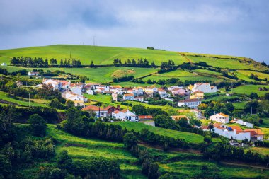 Portekiz, Azores 'teki Sao Miguel adasının kuzeydoğu kıyısındaki Pedreira köyünün manzarası. Portekiz 'in Azores adasının kuzeydoğu kıyısındaki Pedreira köyü ve Pico do Bartolomeu manzarası.