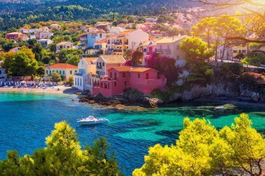 Turquoise colored bay in Mediterranean sea with beautiful colorful houses in Assos village in Kefalonia, Greece. Town of Assos with colorful houses on the mediterranean sea, Greece.  clipart