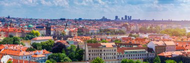 Prag 'ın kırmızı çatıları ve Prag' ın tarihi eski kasabasının düzinelerce kulesi. Güneşli bir günde Prag şehri manzarası. Arka planda kırmızı çatılar, kuleler ve Charles Köprüsü ve Vltava Nehri. Prag, Çek Cumhuriyeti.