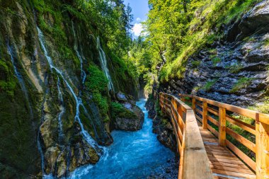 Beautiful Wimbachklamm gorge with wooden path in autumn colors, Ramsau bei Berchtesgaden in Germany. Waterfall at Wimbachklamm near Ramsau-Berchtesgaden, Bavaria, Germany.