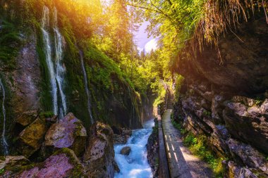 Beautiful Wimbachklamm gorge with wooden path in autumn colors, Ramsau bei Berchtesgaden in Germany. Waterfall at Wimbachklamm near Ramsau-Berchtesgaden, Bavaria, Germany.