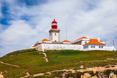 Cabo da Roca 'daki deniz feneri. Portekiz 'in güzel bir yaz gününde Sintra' da Atlantik Okyanusu kıyısındaki kayalıklar ve kayalar. Cabo da Roca, Portekiz. Atlantik Okyanusu üzerindeki deniz feneri ve kayalıklar.