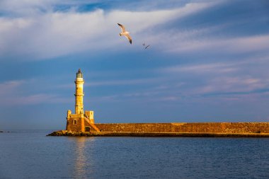 Yunanistan 'ın Girit kentindeki eski Chania limanında, üzerinde martılar uçuşan Venedik limanı ve deniz feneri. Yunanistan, Chania 'daki eski Venedik deniz feneri. Yunanistan 'ın Chania kentindeki eski Venedik limanının deniz feneri.