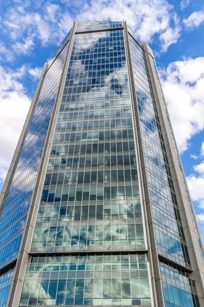 Skla reflexní kancelářské budovy proti modré obloze — Stock fotografie
