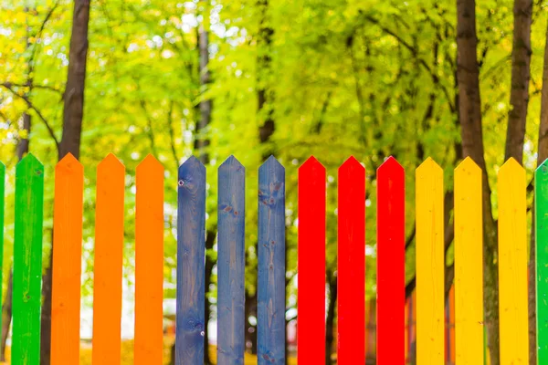 Multi colored rainbow wooden fence in autumn — Stock Photo, Image