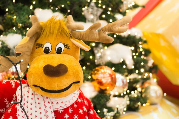 Reno parado junto a un árbol de Navidad — Foto de Stock