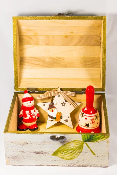 Hombre de nieve, estrella de Santa Claus, campana y caja de madera — Foto de Stock