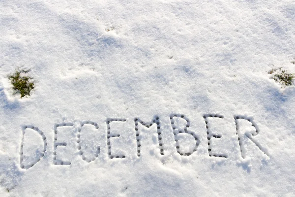 Palabras escritas Diciembre en un campo de nieve . — Foto de Stock