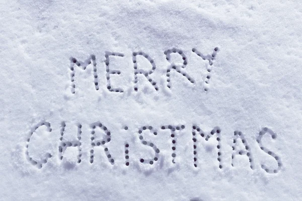 Written words Merry christmas on a snow field