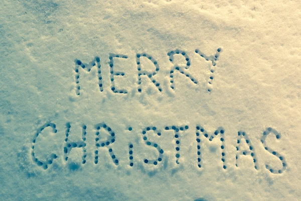 Written words Merry christmas on a snow field