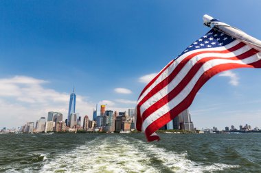 Manhattan kent merkezinin görünümüne ve Liberty Adası'ndan gelen ABD bayrağı
