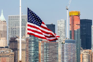 Manhattan kent merkezinin görünümüne ve Liberty Adası'ndan gelen ABD bayrağı