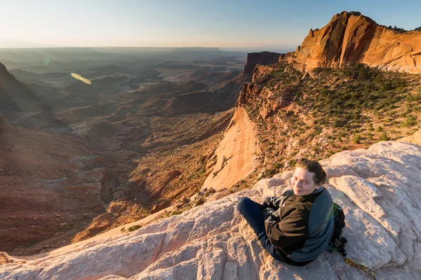 Mädchen sitzt bei Sonnenaufgang am Tafelbogen — Stockfoto