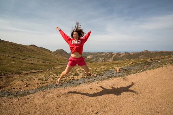 Flicka hoppar på Pikes Peak Mountain Colorado — Stockfoto