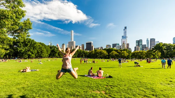 Girl taking selfie and views from the big meadow Central Park to Midtown New York