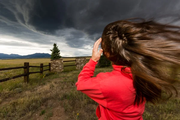 Een meisje permanent tegen de wind — Stockfoto