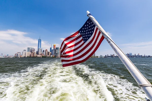 View to Downtown Manhattan and the USA flag from Liberty Island — Stock Photo, Image