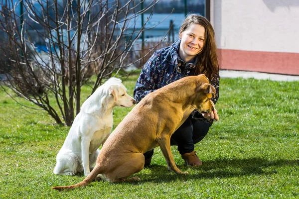 Mujer joven con perros en el jardín —  Fotos de Stock