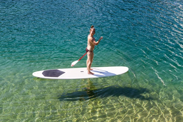 Niña en un paddleboard en el Caumasee en Suiza —  Fotos de Stock