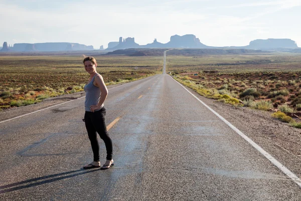 Menina na estrada perto de Monument Valley — Fotografia de Stock